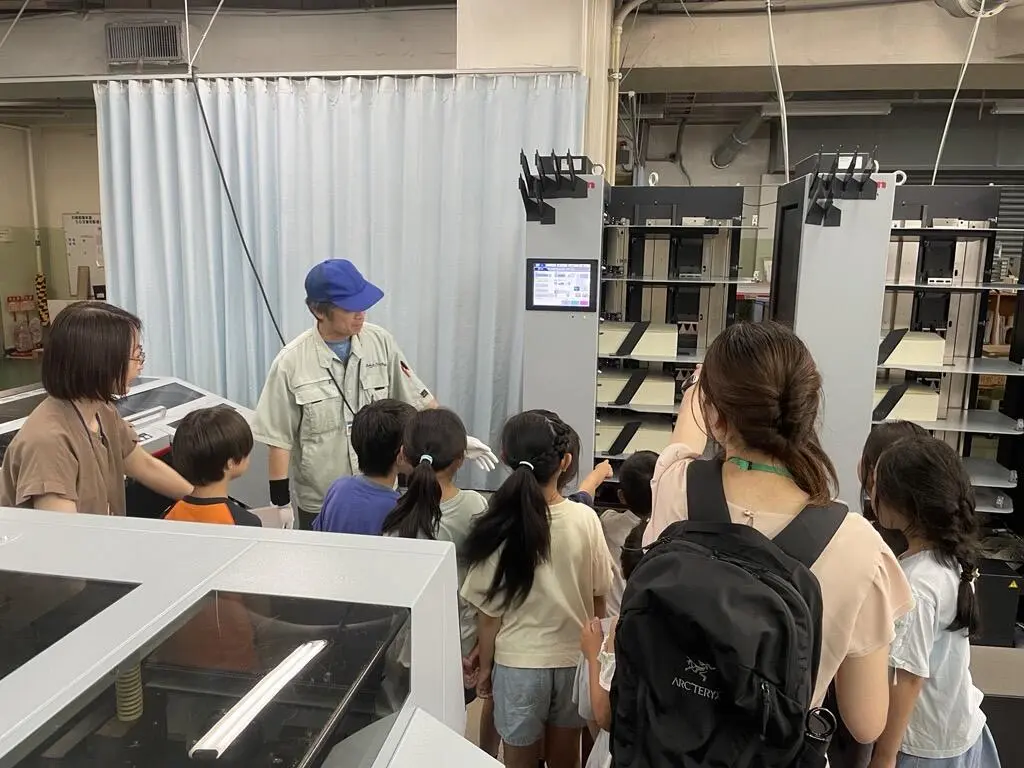 印刷機械について当社社員が学生たちに説明している様子の写真
