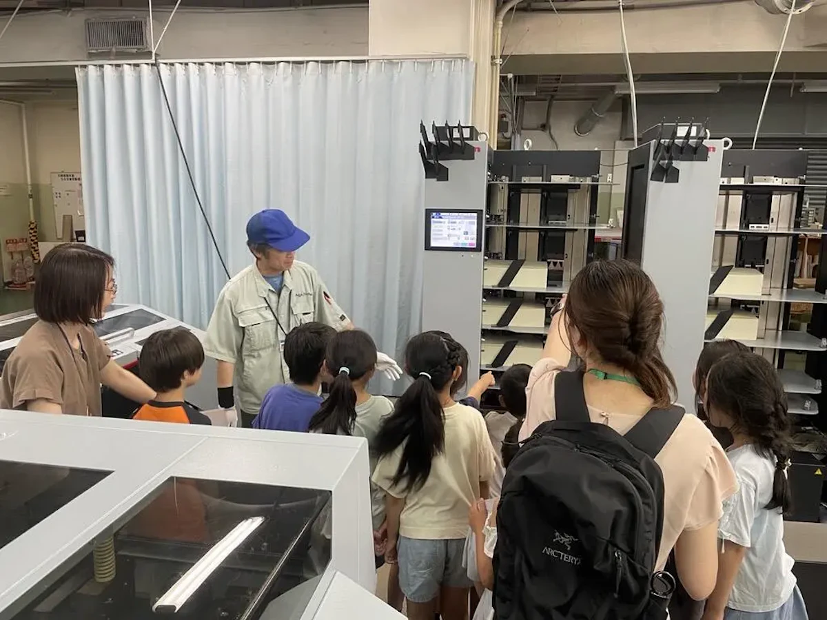 印刷機械について当社社員が学生たちに説明している様子の写真