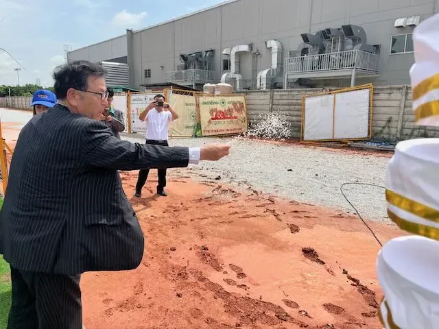 工場建設予定地の土に塩をまいている様子の写真