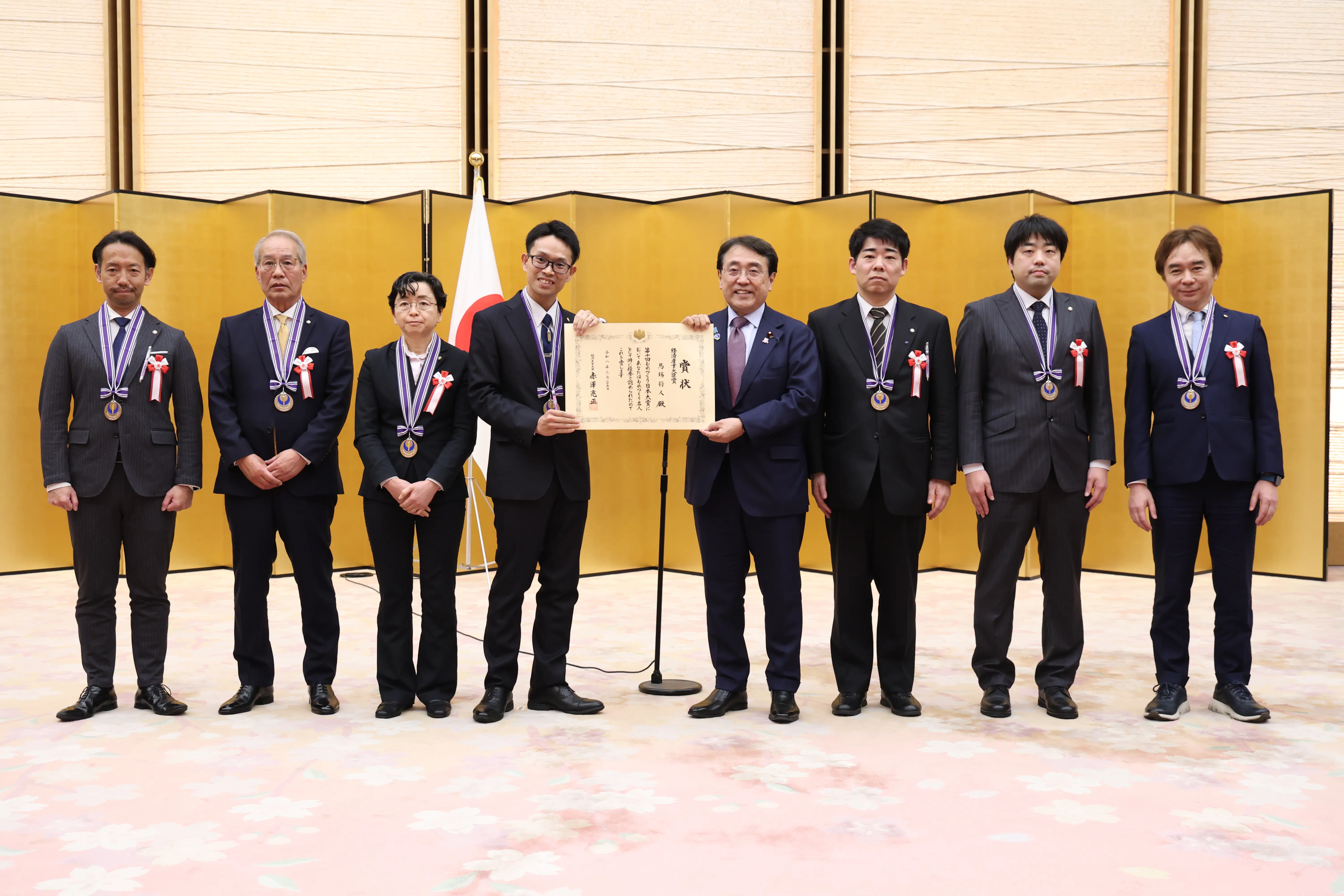 授賞式で表彰状を手に記念撮影をしているチームの画像