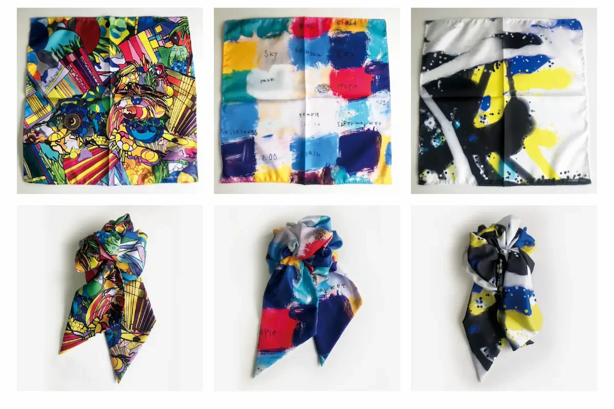 アール・ブリュット作家の水上真歩さん、伊山英吾さん、月音さんの作品が採用されたスカーフの写真