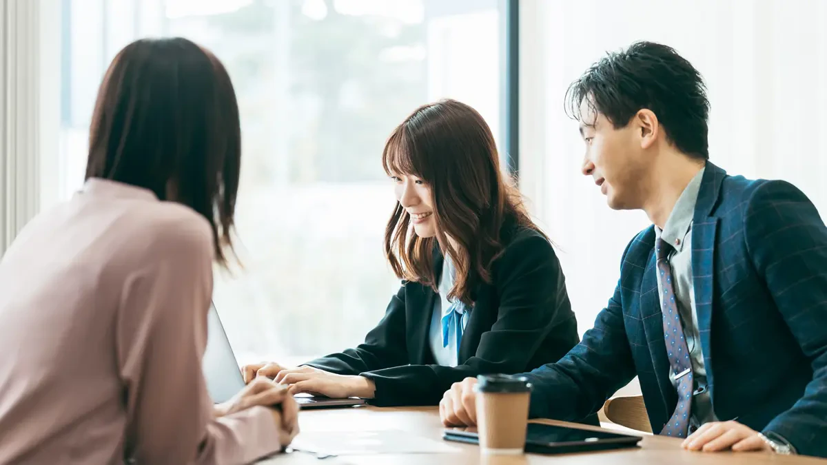 女性2名と男性1名がテーブルを挟んで広報について打ち合わせをしているイメージ画像