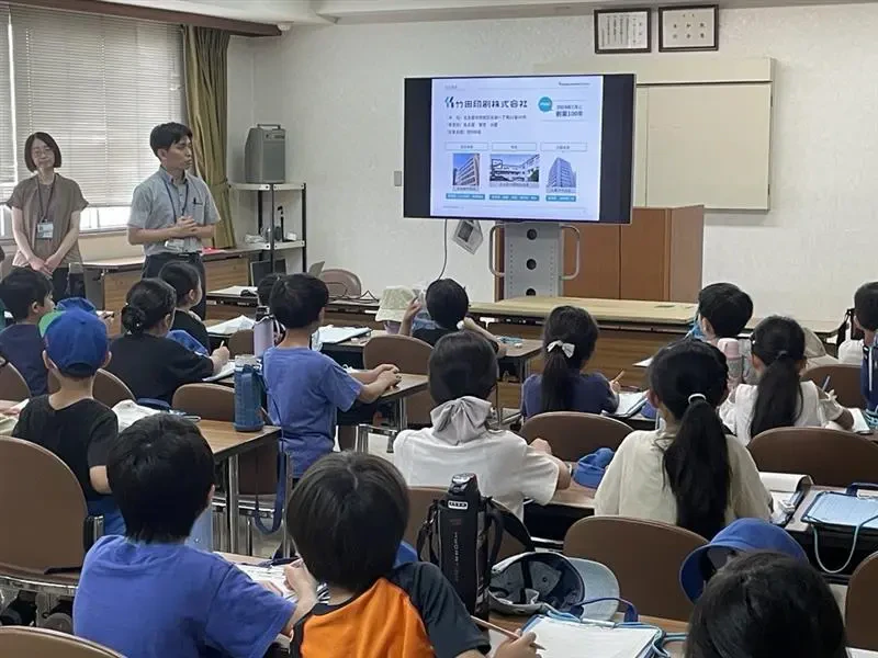 当社の会議室にて、名古屋市立鶴舞小学校の学生たちに竹田印刷について紹介している様子の写真