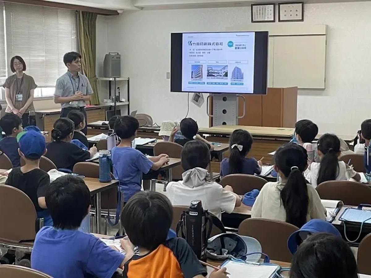 当社の会議室にて、名古屋市立鶴舞小学校の学生たちに竹田印刷について紹介している様子の写真