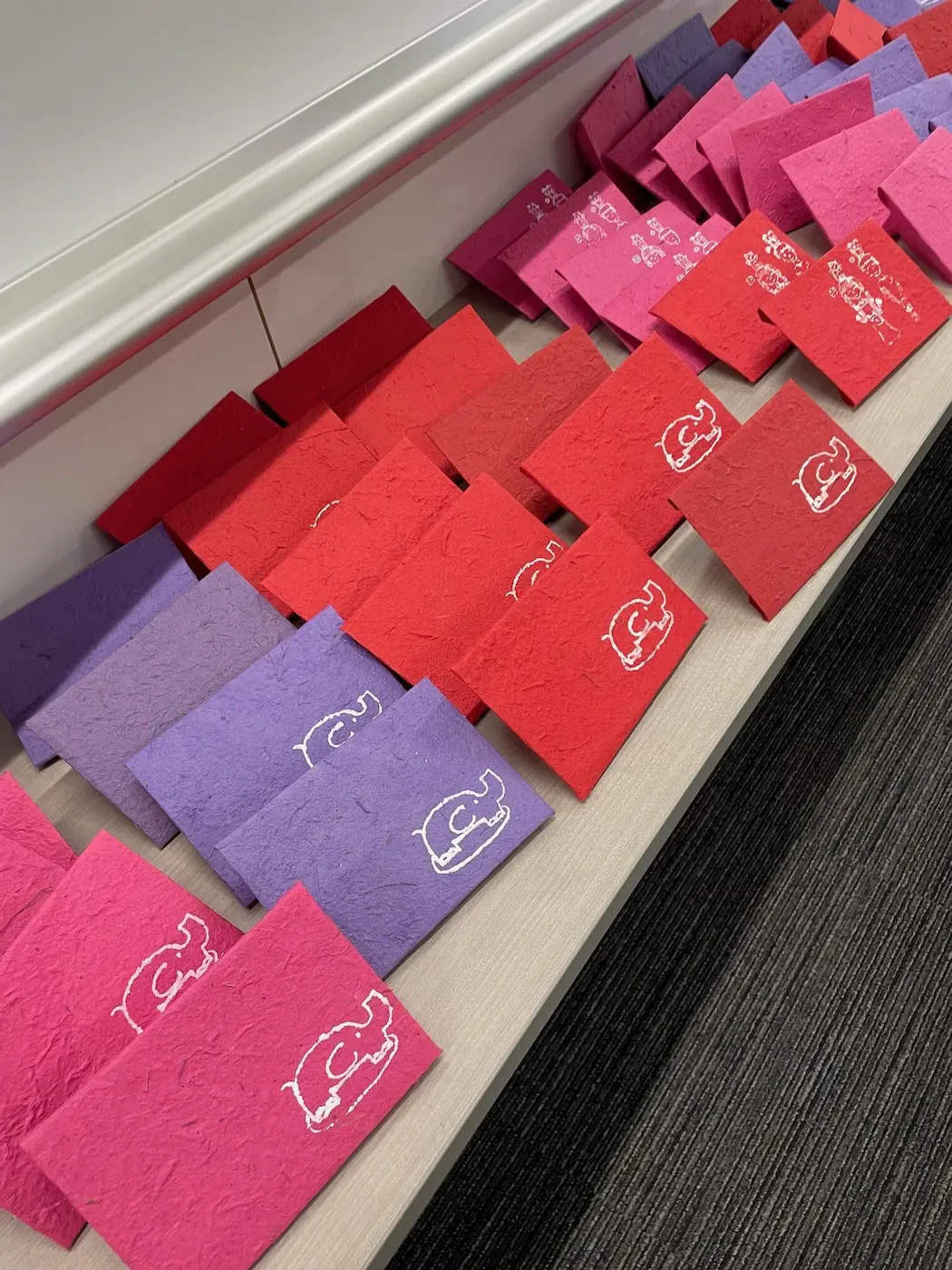 赤色、紫色、ピンク色の色鮮やかな3色のレターセットが陳列された写真