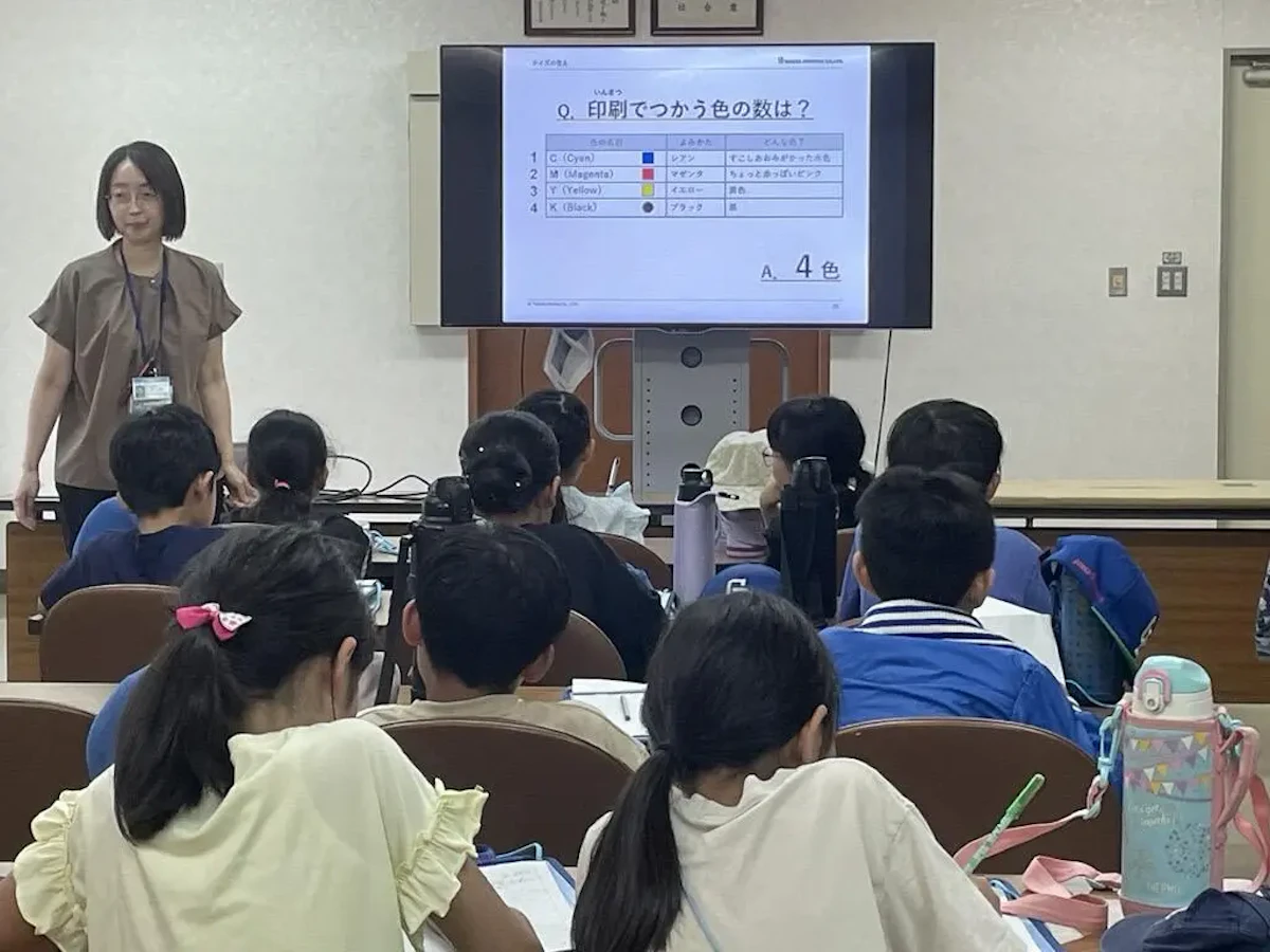 印刷で使う色の数は何色でしょうか？のクイズを出題し、色の数について学んだことを学生たちがノートに書き込んでいる様子の写真