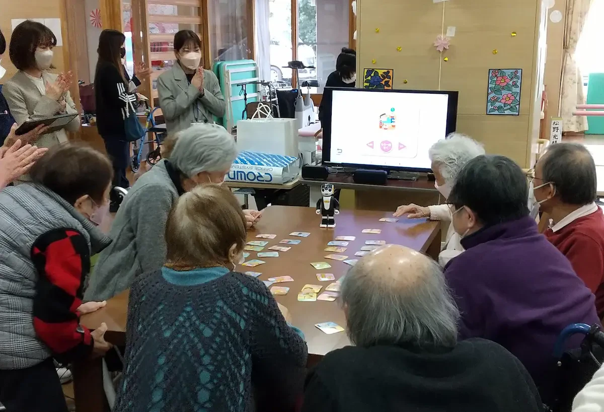 コミュニケーションロボット「ロボホン」を活用し、レクリエーションを行っている様子の写真