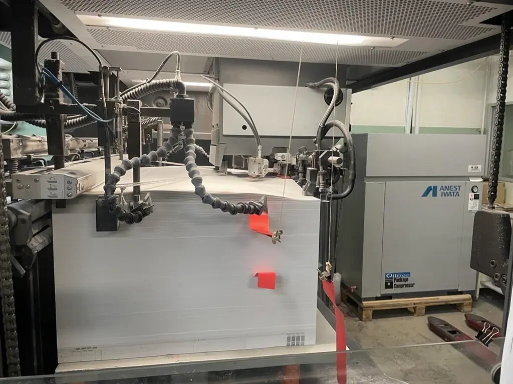 印刷機械と印刷機械にセットされた印刷用紙の写真