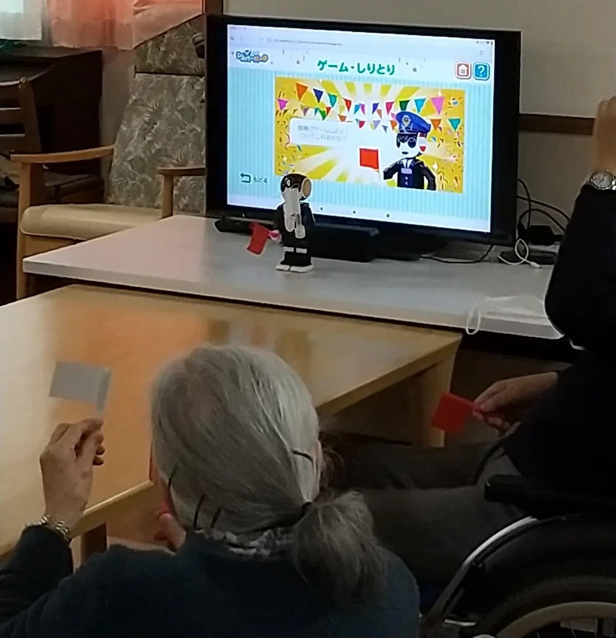 コミュニケーションロボット「ロボホン」を活用し、レクリエーションを行っている様子の写真