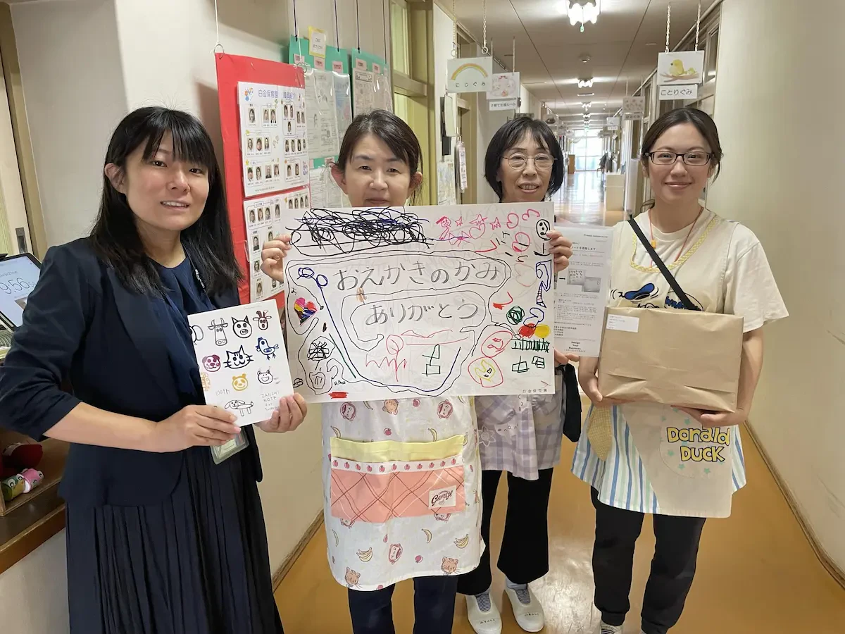 白金保育園の先生方が「残紙ノート」と園児たちからの御礼のメッセージを持っている写真