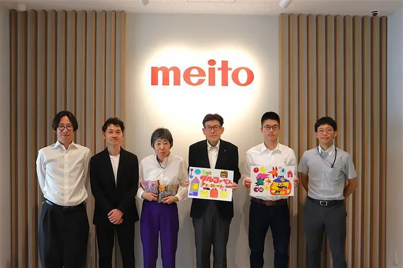 名糖産業株式会社様の企業ロゴマーク看板の前で三矢社長、佐々木紫乃さんと男性4名が映った集合写真