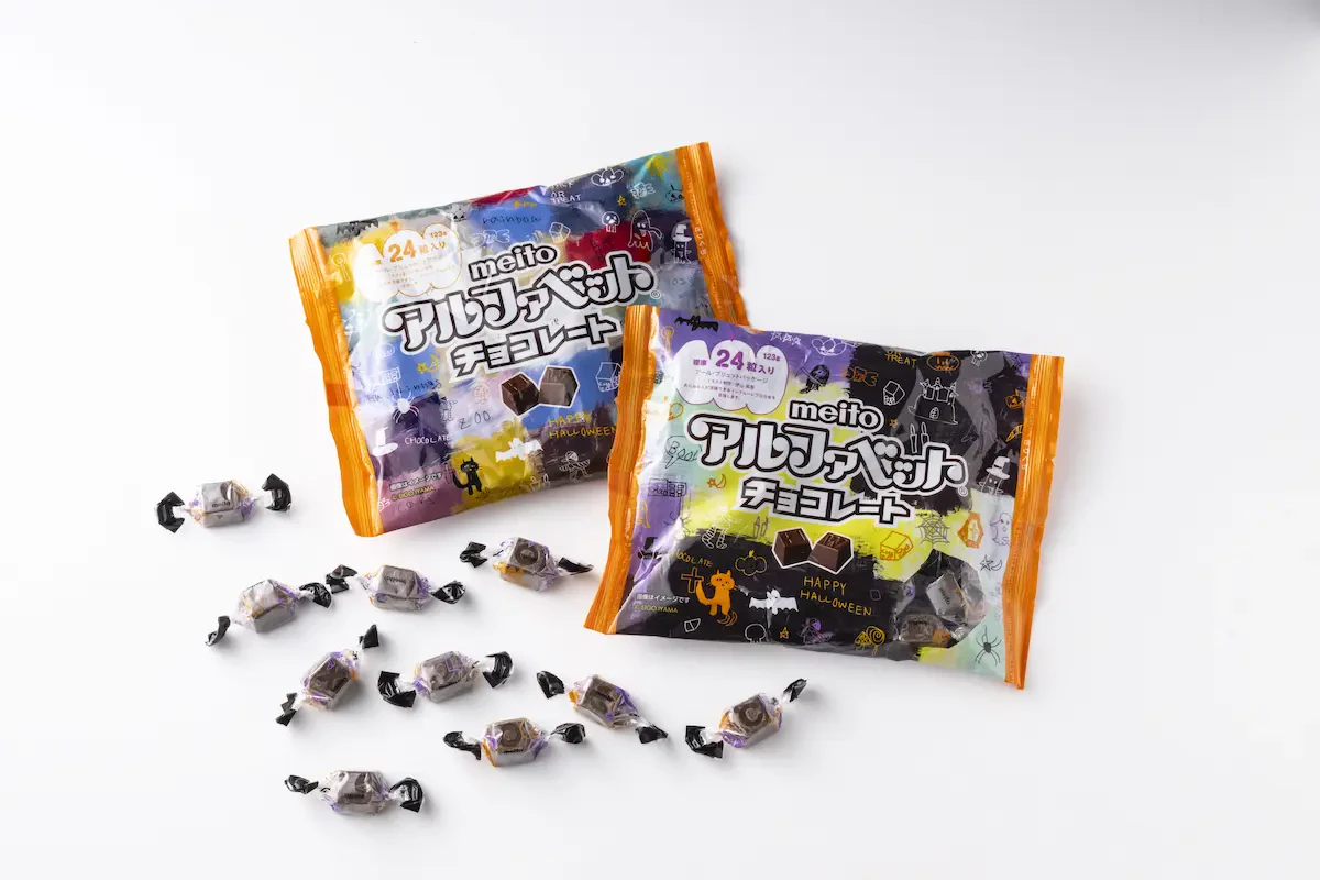 黒色、紫色、オレンジ色をメインカラーに、ハロウィンのイメージイラストが多数散りばめられた2種類のアルファベットチョコレートのパッケージ写真